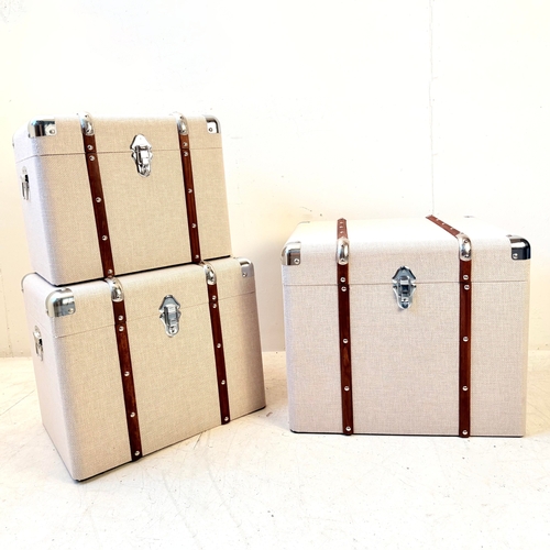 246 - GRADUATED SET OF THREE LUGGAGE STYLE TRUNKS IN LINEN. Largest 50cm H x 50cm W x 50cm D.