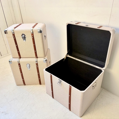 246 - GRADUATED SET OF THREE LUGGAGE STYLE TRUNKS IN LINEN. Largest 50cm H x 50cm W x 50cm D.
