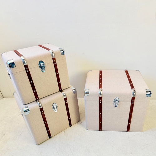 246 - GRADUATED SET OF THREE LUGGAGE STYLE TRUNKS IN LINEN. Largest 50cm H x 50cm W x 50cm D.