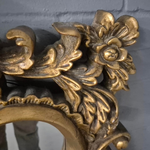 258 - A BAROQUE STYLE RECTANGULAR WALL MIRROR. elaborately moulded and gilded frame, with a large scrollin... 