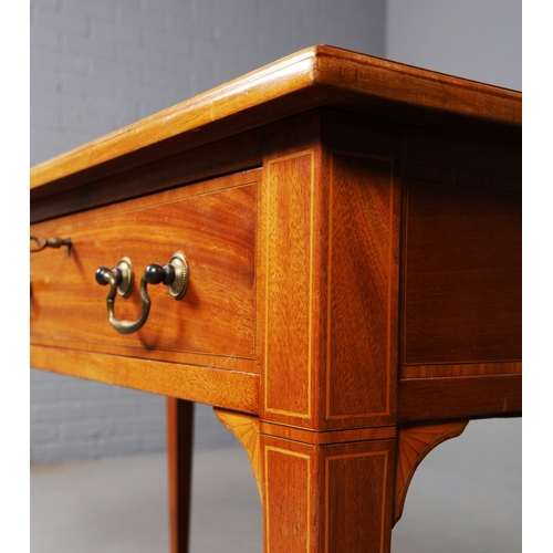 312 - EDWARDIAN MAHOGANY AND INLAID WRITING TABLE. tan leather top above two drawers on brass castors, 75c... 