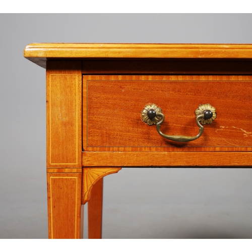 312 - EDWARDIAN MAHOGANY AND INLAID WRITING TABLE. tan leather top above two drawers on brass castors, 75c... 