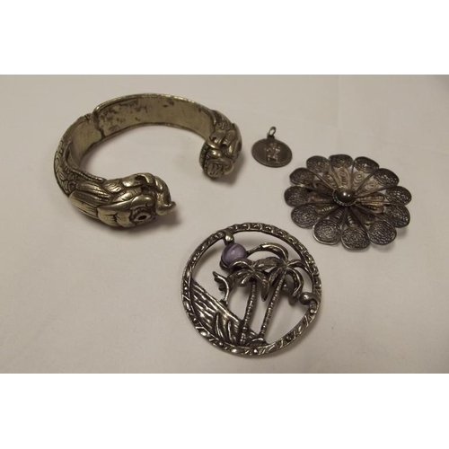 14 - Eastern white metal bangle, white metal filigree brooch, and one other stone set white metal brooch.