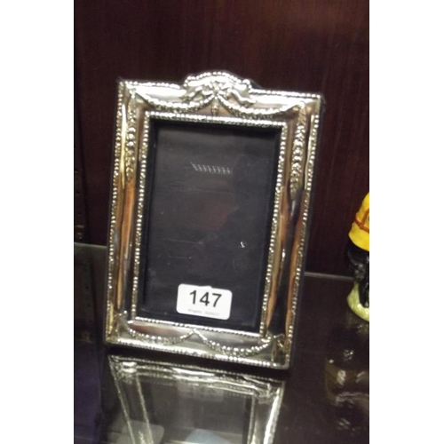147 - Modern rectangular silver faced photograph frame with embossed decoration, 7.75 in. x 5.5 in.