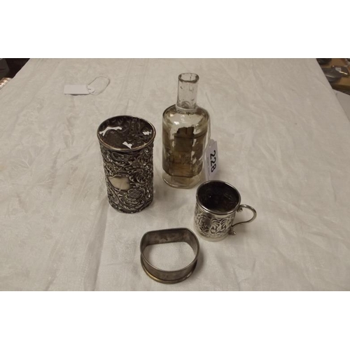 228 - Embossed and pierced silver bottle holder, small embossed silver cup, and a silver napkin ring.