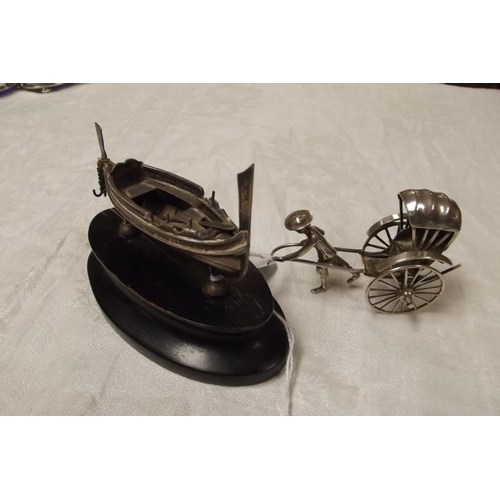 232 - Silver model of an Eastern boat, on ebonised plinth, 3 in. long, and a white metal model of a ricksh... 