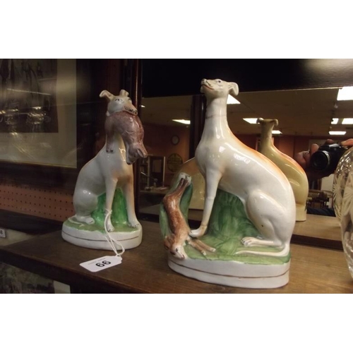 99 - Two 19th Century Staffordshire figures of seated greyhounds with dead hares, 7.5 in. high.