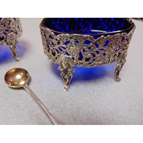 241 - Set of oval cast white metal open salts with blue glass liners, and four silver salts spoons with gi... 