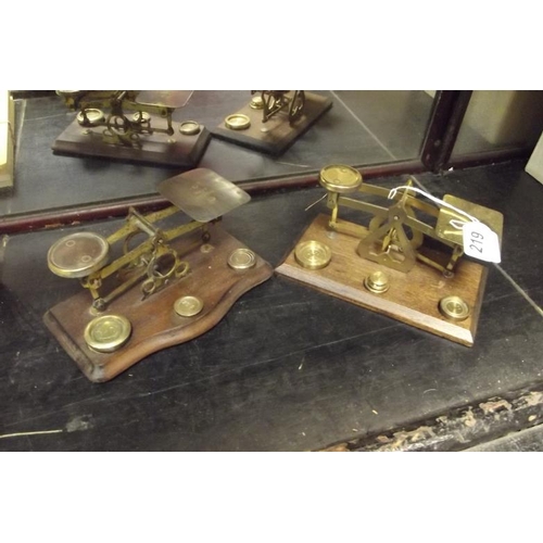 219 - Set of brass postal scales set on wooden stand, and another set of scales. (2)