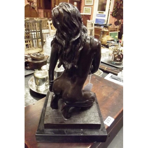 283 - Modern bronze figurine modelled as a female nude kneeling, set on a faux marble base, 12 in. high.