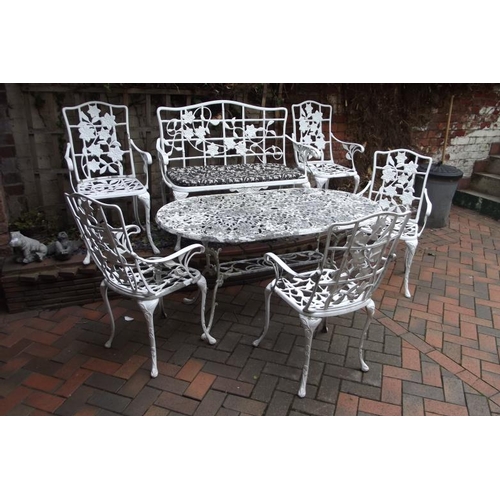 302 - Shaped painted metal garden table, bench, and four chairs having foliate decoration.