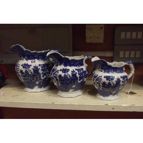 68 - Set of three graduated transfer decorated blue and white jugs.