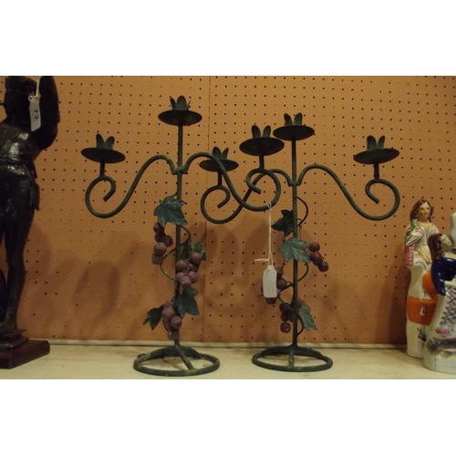 73 - Two wrought metal candle stands.