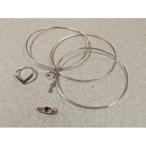 62 - Silver triple bangle with 'lock' and key, silver clog charm, and a silver and stone set wishbone rin... 