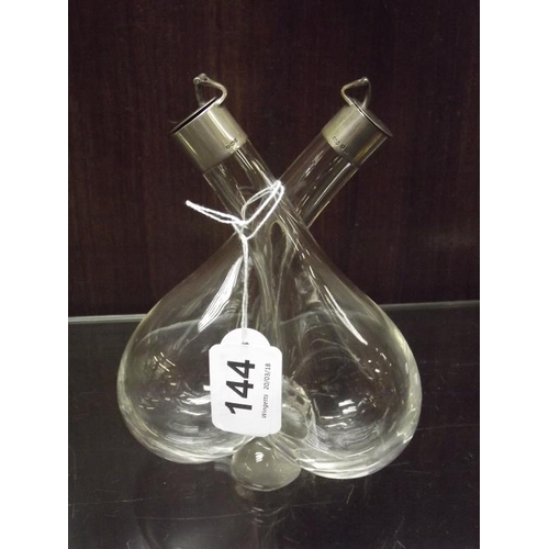 144 - Glass oil and vinegar bottle pair with silver cuffs.