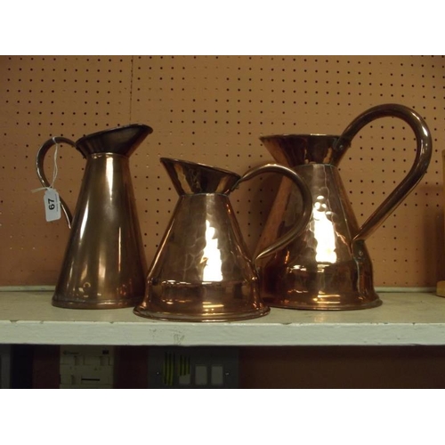 67 - Three various copper jugs.