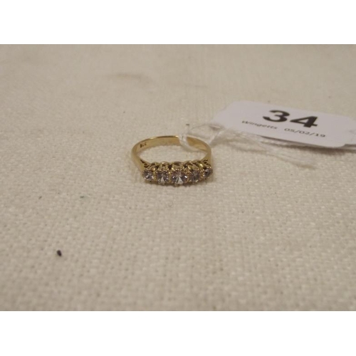 34 - 9 ct. gold ring set with five cubic zirconia stones.