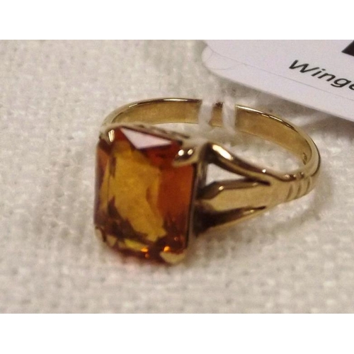 114 - 9 ct. yellow gold ring set with a clear orange stone, size K, 2.6 g.