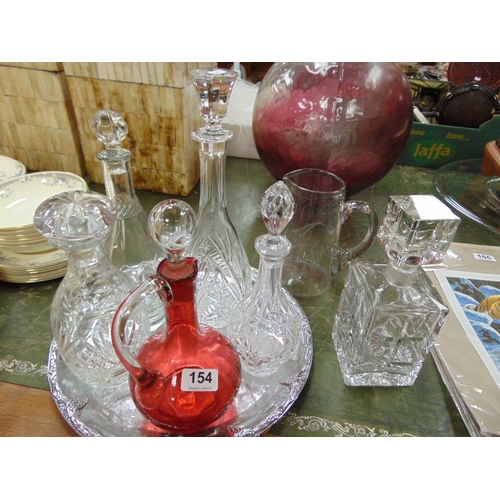 154 - Ruby glass decanter, five others and a circular plated tray.
