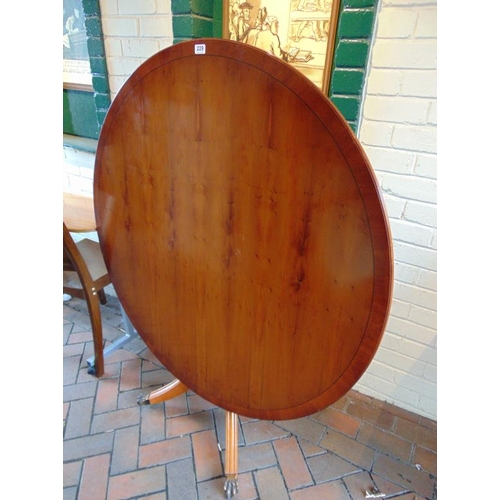 229 - Reproduction yew wood breakfast table having a circular tilt-top and a quarte form base.