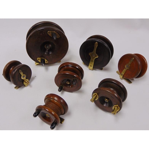 37 - Collection of 7 wooden fishing reels with brass fittings.