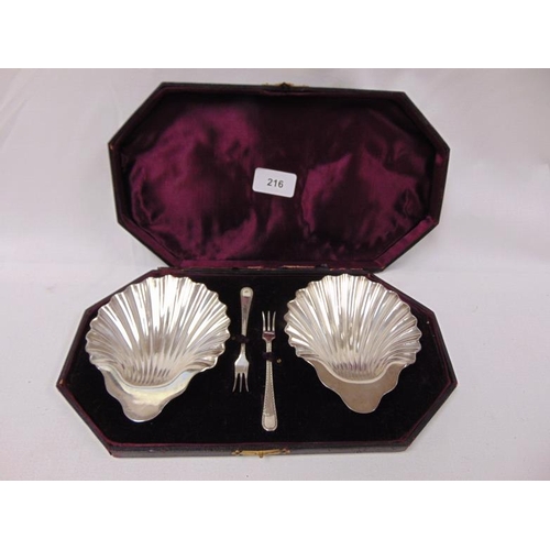 216 - Cased pair of plated shell form pickle dishes and forks.