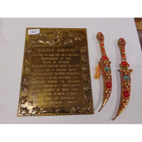219 - Brass embossed plaque, The Lord's prayer - together with a pair of daggers.