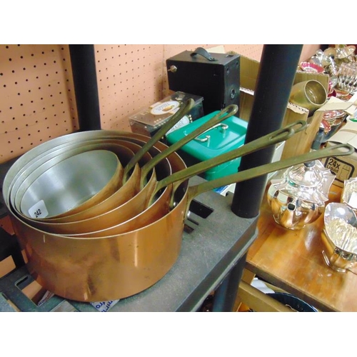 242 - Graduated set of five reproduction saucepans having brass handles.