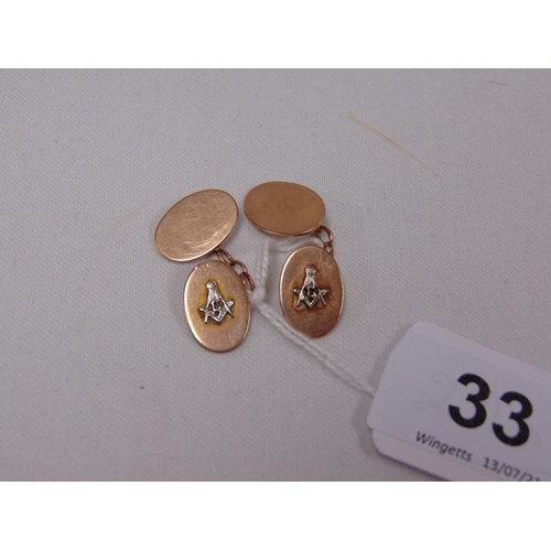 33 - Pair of rose gold cufflinks decorated in relief with Masonic symbols, 6g.