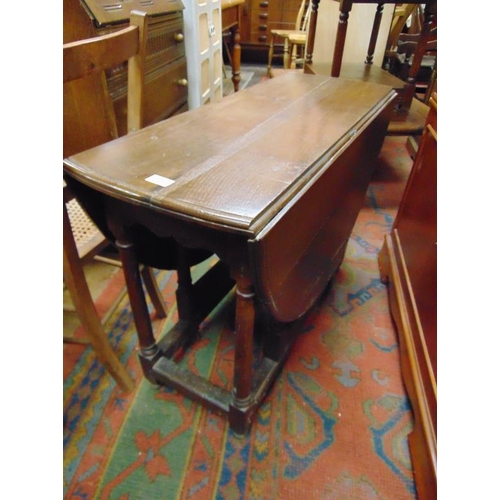 337 - An oak gateleg table, end drawer on baluster turned supports joined by plain stretchers.  26 x 35 x ... 