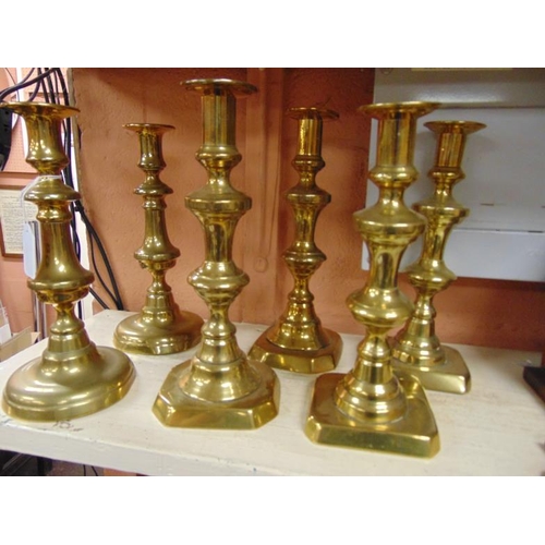 68 - Three pairs of brass candlesticks.