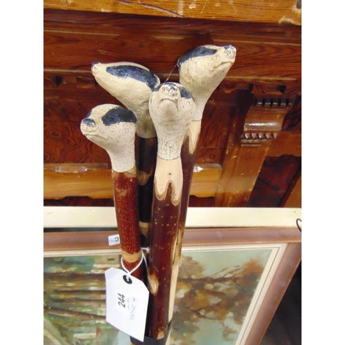 244 - Four walking sticks, each having Badger head handle.