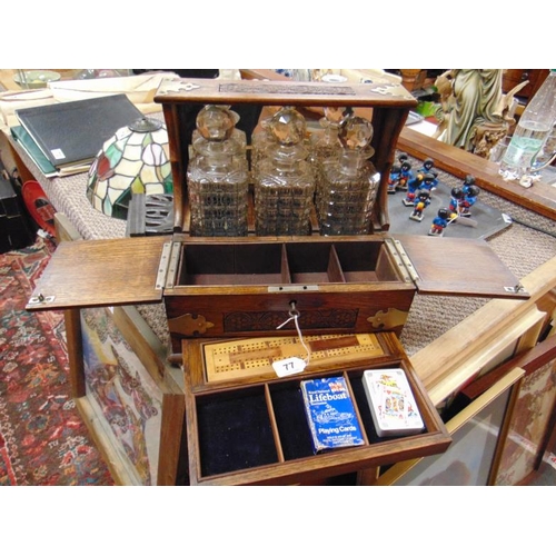 77 - Edwardian three bottle tantalus with plated mounts and fitted drawer.