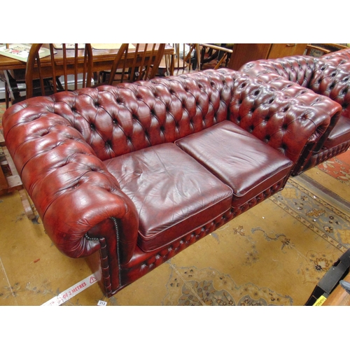 313 - Red leather Chesterfield button back two seater settee and matching pair of single chairs (3).