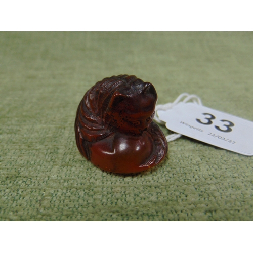 33 - Chinese amber netsuke carved as a curled up cat, 1