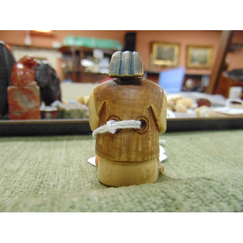 34 - 19th century stained ivory netsuke modelled as a Scribe, signed, 2