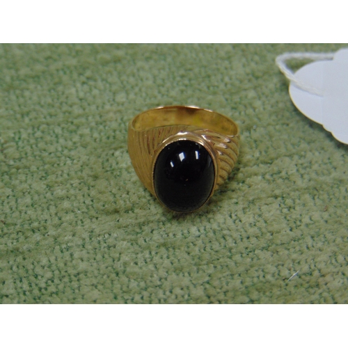 38 - Gold signet ring set with a black cabuchon stone, stamped 14k, size Q, 4.7g.