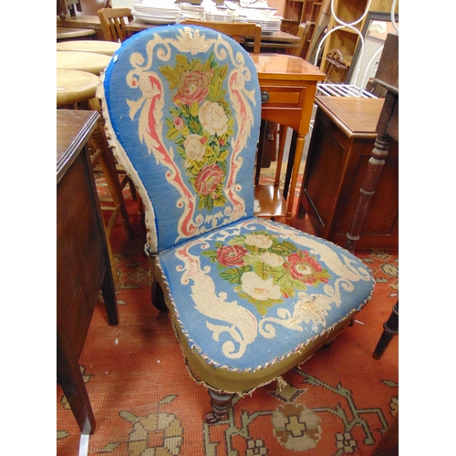 371 - 19th century nursing chair, needlework back and seat, on short turned frontal supports and castors.