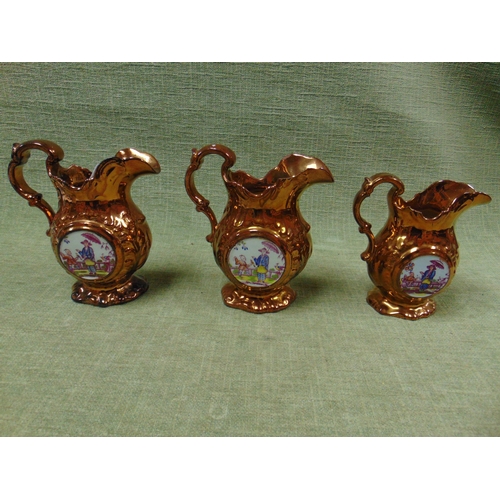 162 - Copper lustre 'clock' jug and two similar jugs. (3).