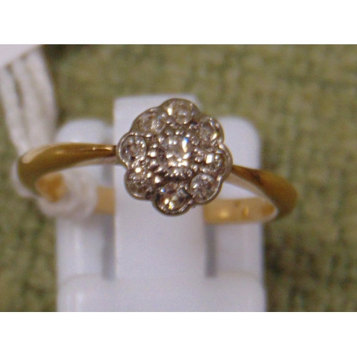 56 - 18ct gold ring with central diamond surrounded by seven smaller diamonds in a floral setting, size L... 