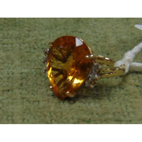 58 - 9ct gold ring set with a large pear cut orange stone, size K, 5g.