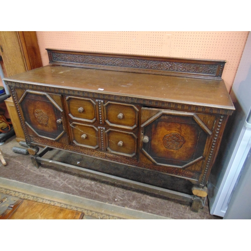 341 - An oak sideboard, raised back, above pair of central drawers flanked by cupboard doors and on plain ... 