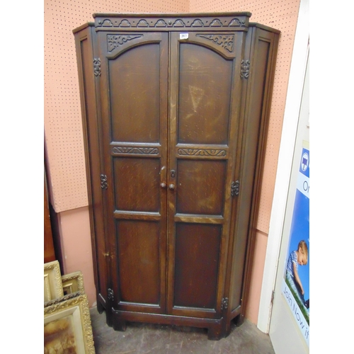 365 - Reproduction oak hanging corner cupboard, having pair of panel doors. 71 x 41