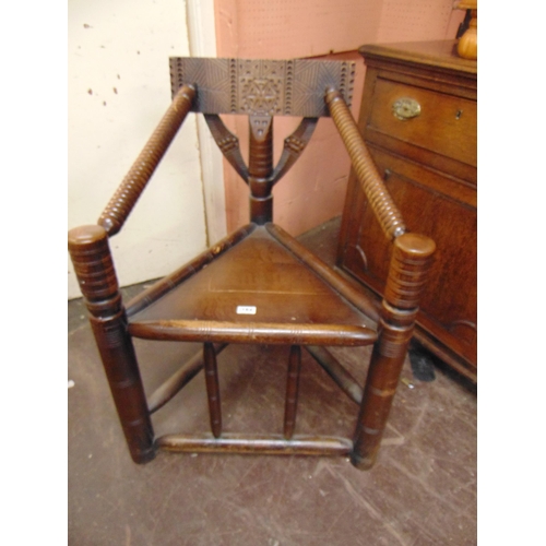 184 - An oak corner  turner's chair, carved decoration, solid seat and on turned supports.