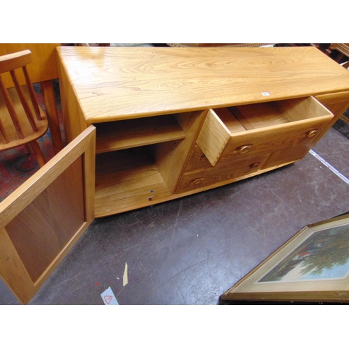 251 - An Ercol Golden Dawn sideboard, having three central long drawers flanked by cupboard doors, and on ... 