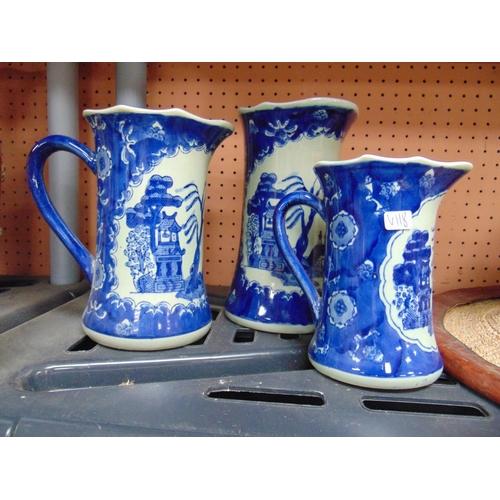 282 - Graduated set of three willow pattern jugs.