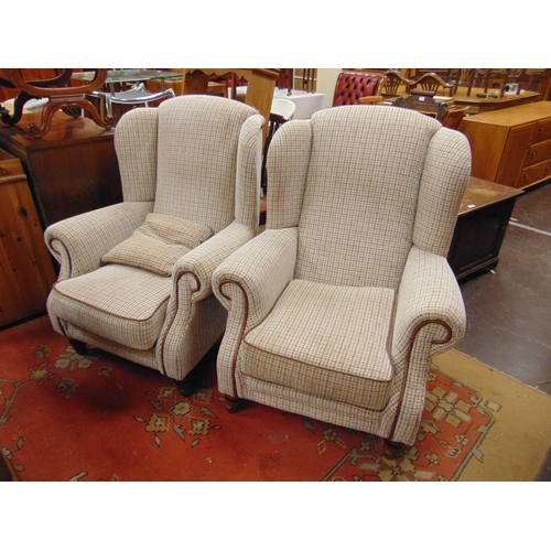 297 - Pair of wing back lounge chairs, having all over upholstery and on short turned supports.