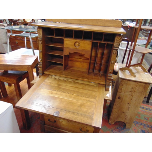 325 - An oak secretaire a abattant, fall front revealing a fitted interior, three long drawers with metal ... 