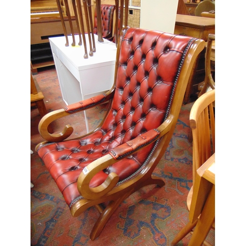 328 - Antique style red leather button back library chair, scroll arms and on shaped supports.