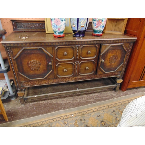 341 - An oak sideboard, raised back, above pair of central drawers flanked by cupboard doors and on plain ... 